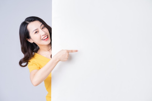 Obraz młodej azjatyckiej kobiety z białą tablicą