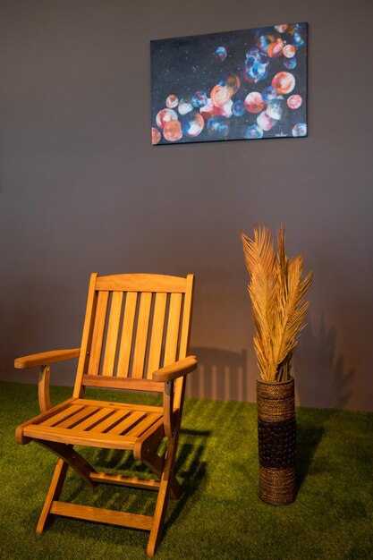 Obraz na ścianie pokoju z krzesłem i wazonem z kwiatami.