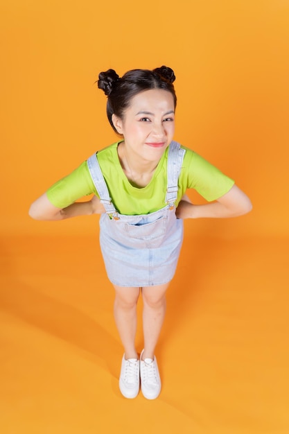 Obraz pełnej długości młodej azjatyckiej kobiety stojącej na tle
