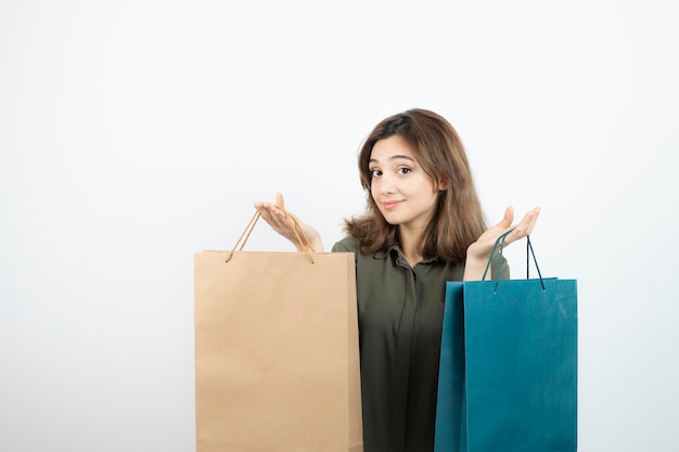 Obraz piękna dziewczyna z krótkimi włosami, trzymając torby na zakupy. Zdjęcie wysokiej jakości