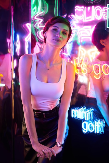 Obraz pięknej dziewczyny w parku rozrywki w pokoju z neonowym światłem Koncepcja rozrywki