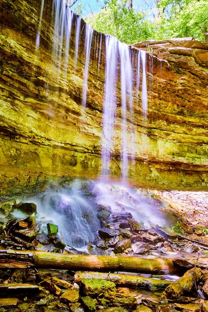 Obraz przedstawiający wodospad kapiący z klifów na skały