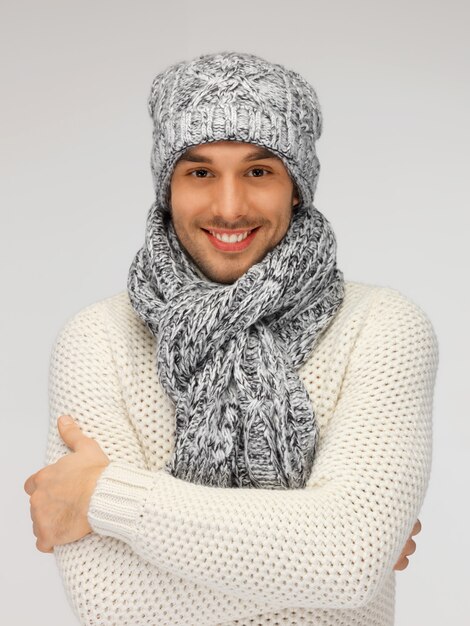 obraz przystojnego mężczyzny w ciepłym swetrze, czapce i szaliku.