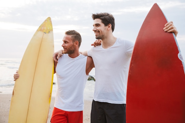 Obraz Szczęśliwy Młodych Wesołych Pozytywnych Dwóch Mężczyzn Surferów Przyjaciół Z Surfingu Na Plaży Na Zewnątrz.