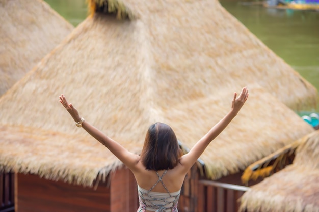 Obraz za kobietami podnoszącymi ręce patrzył na drewnianą tratwę na wodzie w Resort Wangnokkaew Park View Kanchanaburi, Tajlandia