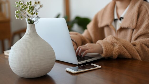 Obraz zbliżenia Kobieta pilotka pracująca w minimalnej przytulnej kawiarni i pracująca na laptopie