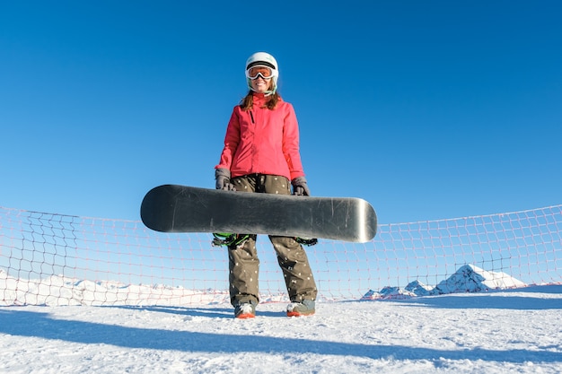 Obrazek szczęśliwy młodej damy snowboarder na stokach