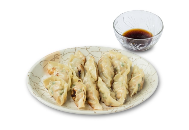 Obrazek z pierogami lub gyozas z sosem sojowym na białym tle