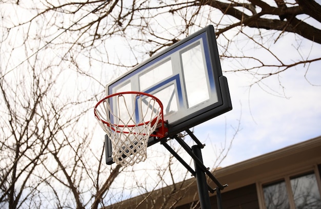 Obręcz do koszykówki jest pokazana na podwórku mieszkalnym.