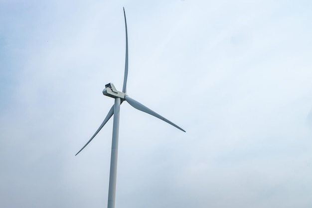 Obrotowe łopaty śmigła wiatraka na tle błękitnego nieba Wytwarzanie energii wiatrowej Czysta zielona energia