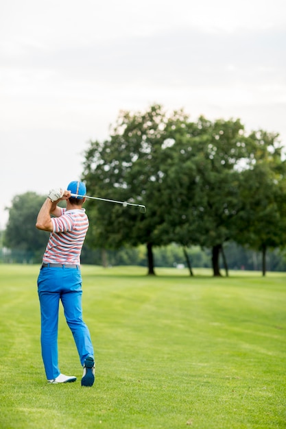 Zdjęcie obsługuje bawić się golfa na słonecznym dniu na pięknym polu golfowym