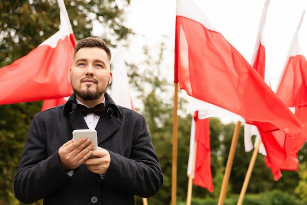 Zdjęcie obsługuje mienia smartphone z flaga polska behind