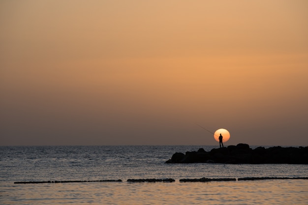 Obsługuje połów, niskie słońce przy Amadores plażą na Gran Canaria wyspie w Hiszpania.