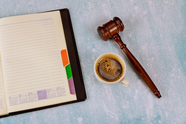Obszar roboczy z pustym notatnikiem Sędzia młotek prawny na filiżance kawy espresso