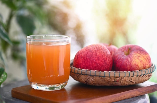 Ocet jabłkowy naturalne środki i lekarstwa na powszechny stan zdrowia surowy i niefiltrowany organiczny ocet jabłkowy w szkle z owocami jabłka na drewnianym stole