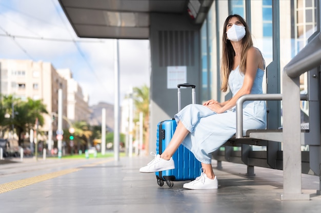 Ochrona przed wirusami w transporcie publicznym. Kobieta podróżująca w masce ochronnej. Koncepcja pandemii i zanieczyszczenia wirusa. Kobieta czeka na stacji kolejowej.
