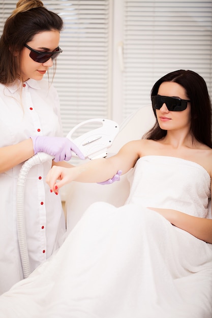 Ochrona skóry. Dorosła kobieta o laserowe usuwanie włosów w profesjonalnym salonie kosmetycznym