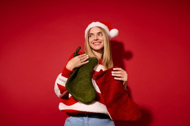 Oczekiwany. Dziewczyna w santa hat trzyma świąteczne pończochy