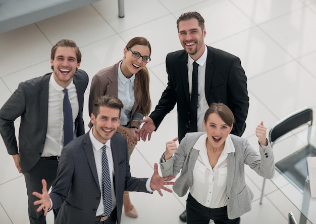 Od góry szczęśliwy zespół biznesowy stojący w koncepcji sukcesu biura