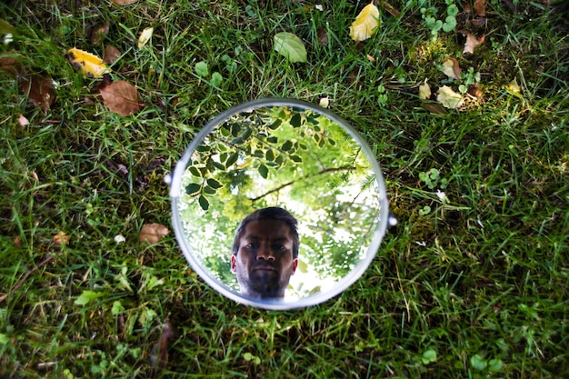 Zdjęcie odbicie człowieka w lustrze na polu