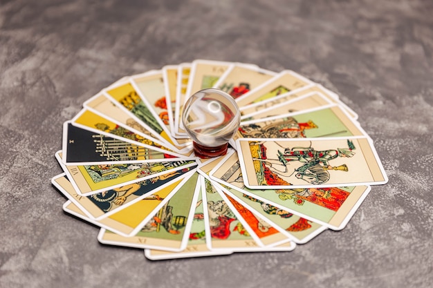 Zdjęcie odbicie kart tarota przez magiczną kulę na biurku wróżki