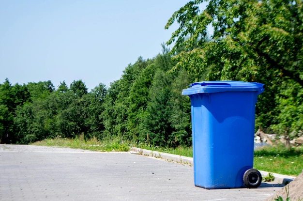 Odblokowany duży pusty niebieski plastikowy kosz na śmieci