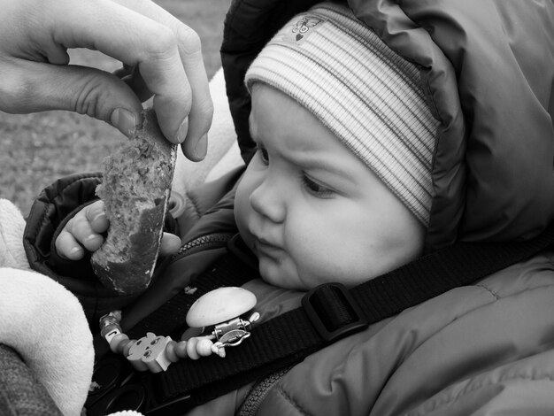 Zdjęcie odcięta ręka dająca chleb dziecku