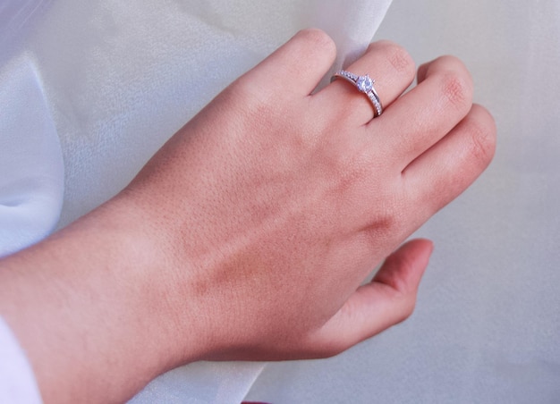 Zdjęcie odcięta ręka kobiety noszącej pierścionek z diamentem