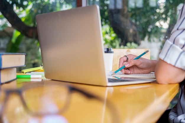 Odcięta ręka kobiety używającej laptopa