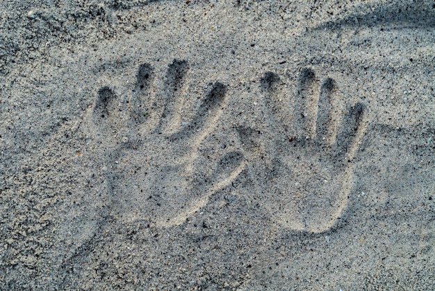 Odcisk dłoni na piasku plaży