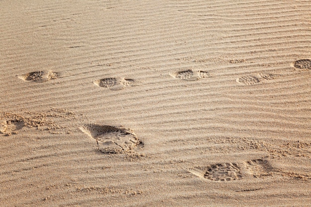 Odciski stóp w piasku w wydmach Zbliżenie Z góry Przestrzeń dla tekstu Tło