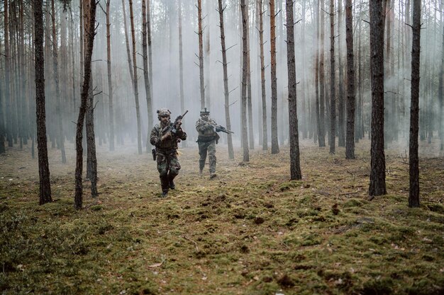 Oddział czterech w pełni wyposażonych żołnierzy w kamuflażu na karabinach rozpoznawczych misji wojskowej