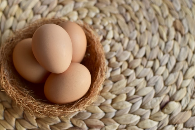 Odgórny widok brown kurczaka / kurzych jajka w gniazdeczku na górze naturalnej maty