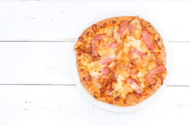 Odgórny widok hawajska pizza na drewnianym bielu stołu tle.