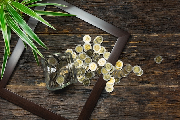 Odgórny widok sterta moneta w ramowym księgowości pojęciu na drewnianym tle.