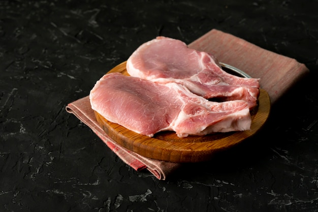 Odgórny widok surowego mięsa uncooked plasterki, rżnięta wieprzowina na drewnianej desce odizolowywa