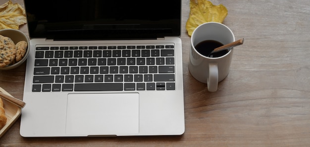 Odgórny widok wygodny miejsce pracy z laptopem i filiżanką kawy na drewnianym stole