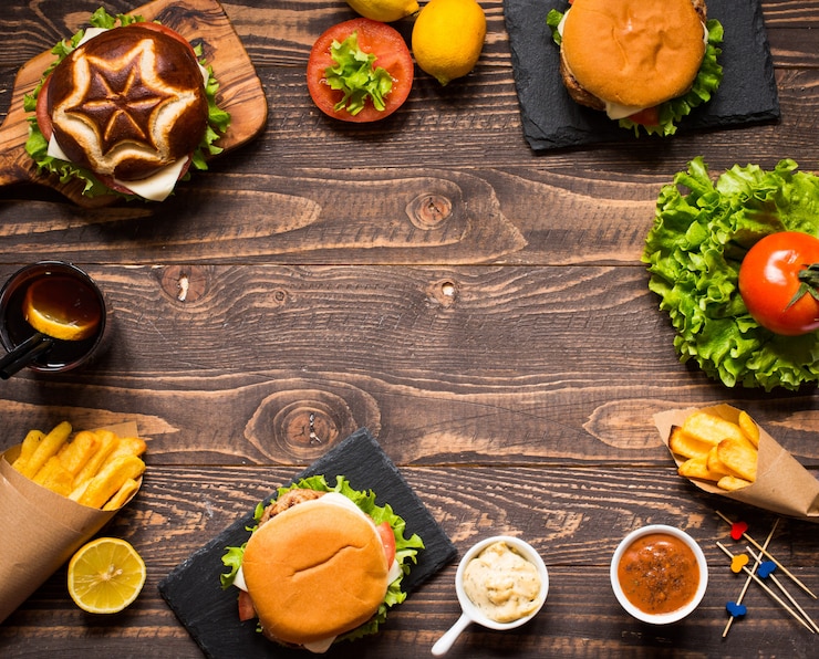 Zdjęcie odgórny widok wyśmienicie hamburger z warzywami, na drewnianym tle.