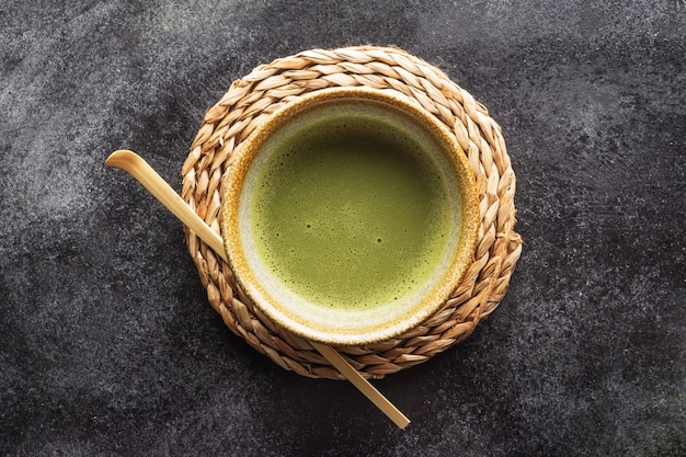 Odgórny widok zielonej herbaty matcha w pucharze na zmroku stole