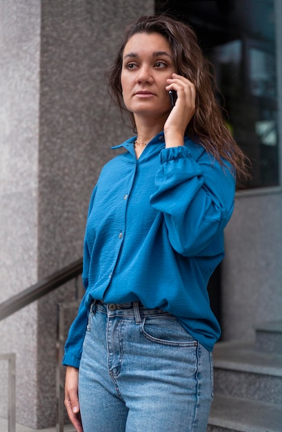 Odkryty portret młodej kobiety rozmawiającej przez telefon w mieście