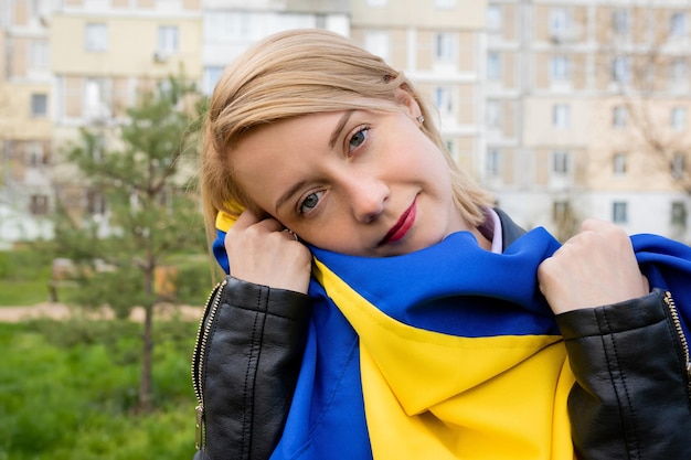 Odkryty portret młodej kobiety z flagą Ukrainy na ulicy miasta Koncepcja wolności