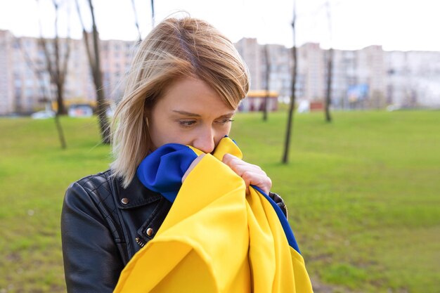 Zdjęcie odkryty portret smutnej kobiety z flagą ukrainy na zewnątrz w parku koncepcja bezpłatnego stylu życia
