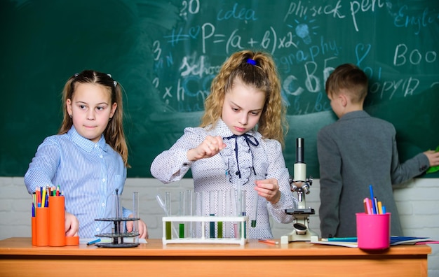 Odkrywaj cząsteczki biologiczne Przyszła koncepcja technologii i nauki Dzieci uczą się biologii lub chemii w szkole Edukacja w szkole Uczą się uczennice Dzieci w klasie z mikroskopem i probówkami