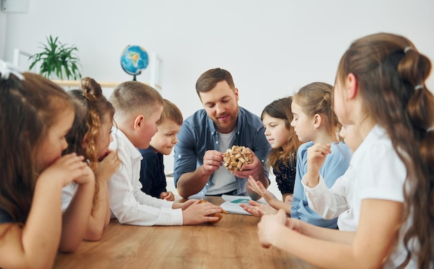 Odkrywanie puzzli Grupa uczniów w klasie w szkole z nauczycielem