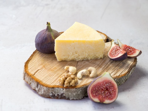 Odmiana twardego sera z figami i orzechami na drewnianej desce do krojenia