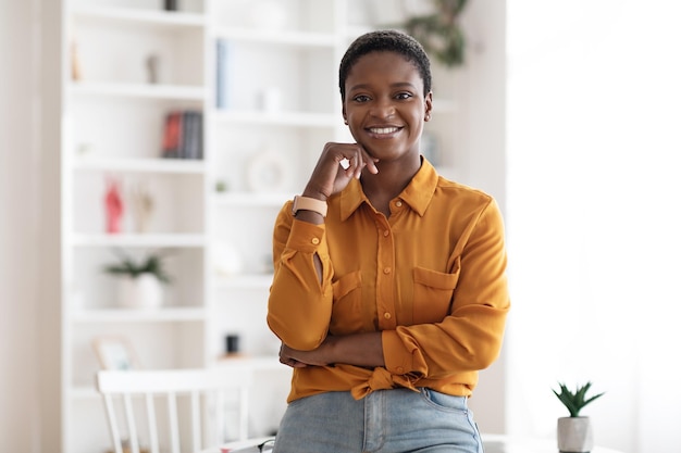 Odnosząca sukcesy młoda czarna biznesowa kobieta pozuje w biurze