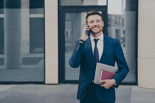 Odnoszący Sukcesy I Pewny Siebie Właściciel Firmy Rozmawia Przez Telefon Ze Swoim Pracownikiem Na Zewnątrz