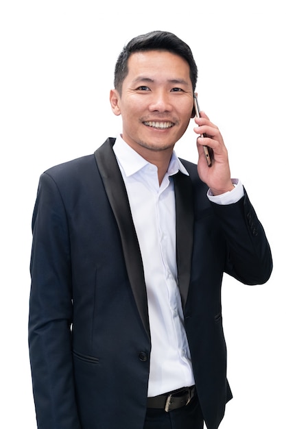 Odosobniony azjatykci biznesmen w kostiumu używa telefon komórkowego na białym tle w businesss pojęciu