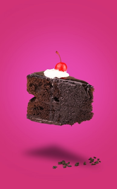 Odosobniony czekoladowy wiśnia torta latanie na różowym tle