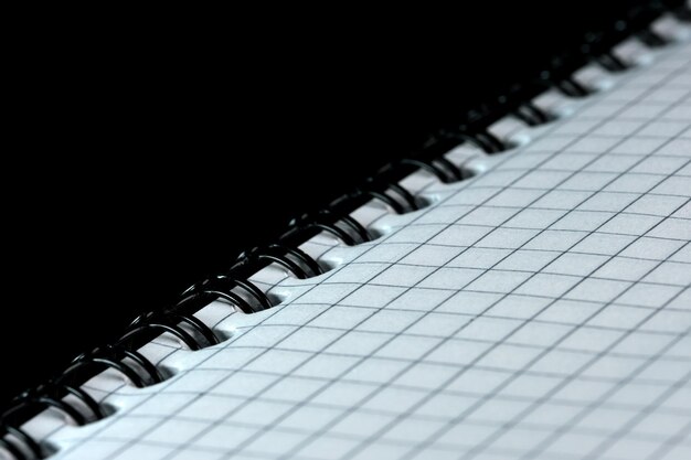 Odrywany notatnik na notatki z kartkami w pudełku ze spiralną oprawą na czarnym lustrzanym tle, zbliżenie
